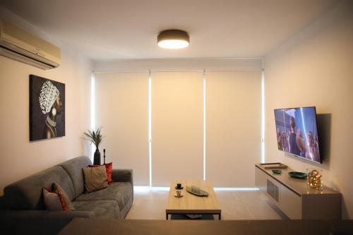 a living room with a couch and a table at Lovely cozy one bedroom suite with pool in Protaras