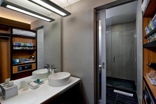 a bathroom with a white sink and a shower at Aloft Tulsa Downtown in Tulsa