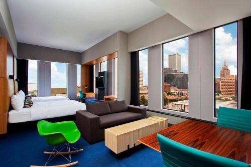 a hotel room with a bed and a large window at Aloft Tulsa Downtown in Tulsa