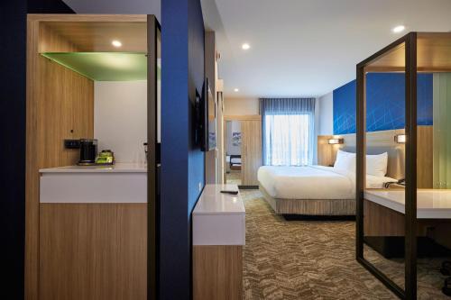 um quarto de hotel com um quarto com uma cama e uma cozinha em SpringHill Suites by Marriott Medford Airport em Medford