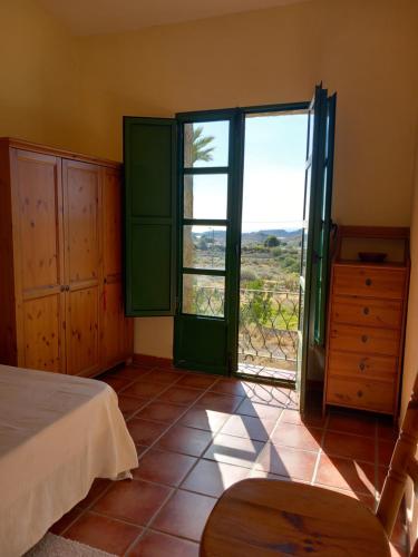 a bedroom with a bed and a large window at El Retiro - Casa Vibrante in Pilar de Jaravía