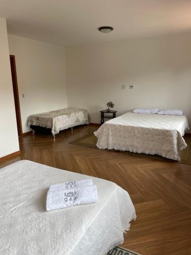 - une chambre avec 2 lits et du parquet dans l'établissement Suítes no Paraíso, à Espera Feliz