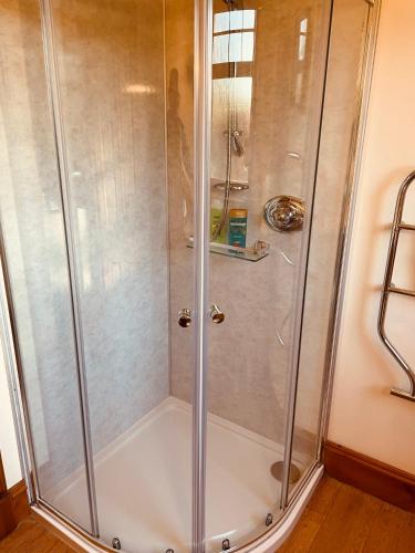 a shower with a glass door in a bathroom at Talisker in Nairn