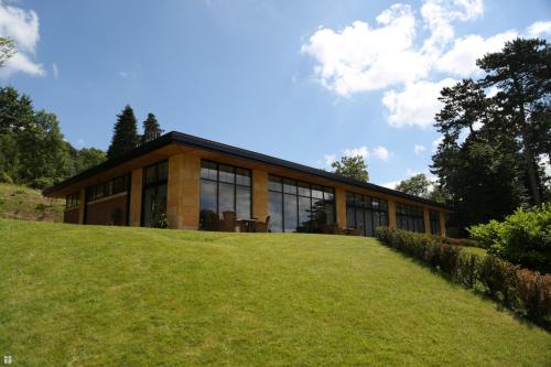 a house on top of a grassy hill at The Wood Norton in Evesham