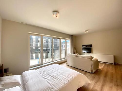 Un dormitorio con una cama y un sofá y una ventana. en Studio hypercentre Bruxelles, en Bruselas