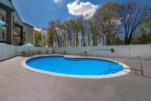 a swimming pool on a patio next to a fence at Quality Inn & Suites Airport in Charlotte