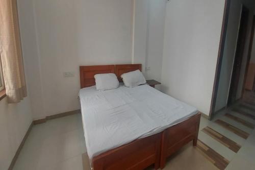 a bed with two pillows on it in a room at SPOT ON Shyam Dharamshala in Haridwār