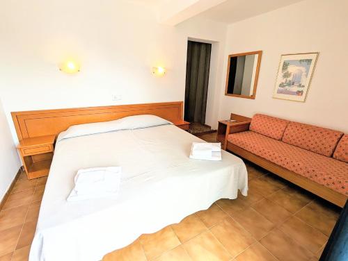 a hotel room with a bed and a couch at Don Carlos in Paguera