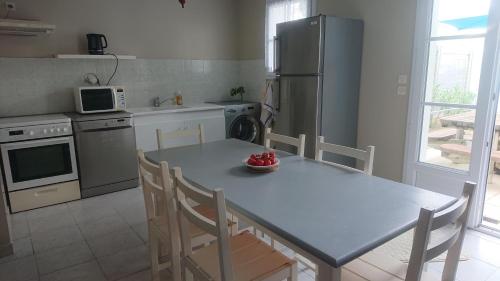 une cuisine avec une table avec des chaises et un réfrigérateur dans l'établissement Maison 6 personnes à l'Ile de Ré, au Bois-Plage-en-Ré