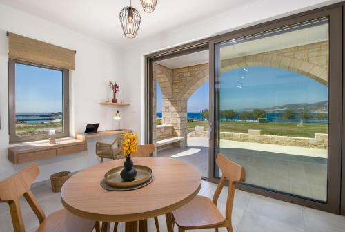 a dining room with a table and chairs and a large window at Christos Place-Paleochora in Palaiochora