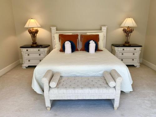 a bedroom with a large white bed with two night stands at 7000 sf: 5 king / 1 queen / 7 single beds, heated pool/spa, designer furnishings in Flowery Branch