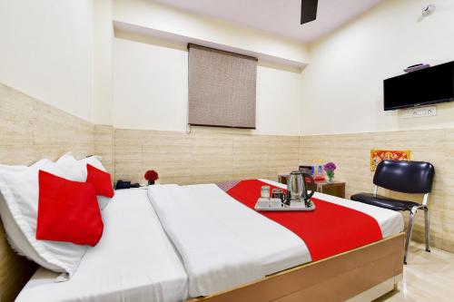 a bedroom with a bed with a desk and a television at Super OYO Hotel Tourist Residency in Jaipur