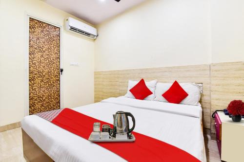 a hotel room with a bed with red accents at Super OYO Hotel Tourist Residency in Jaipur