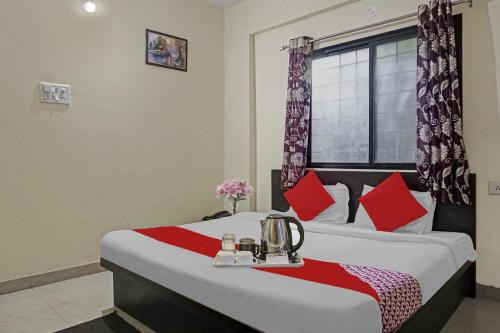 a bedroom with a large bed with red pillows at R K Exclusive in Hinjewadi