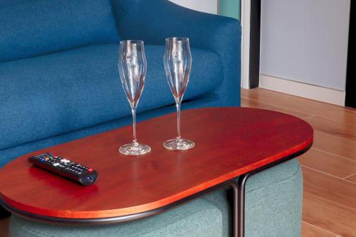 una mesa con dos copas de vino y un mando a distancia en ella en Casa Vitoria en Aguilar de Campóo