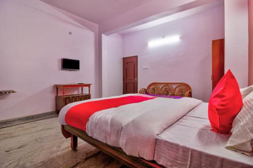 - une chambre avec un grand lit et des oreillers rouges dans l'établissement OYO Atithi Bhawan, à Jamshedpur