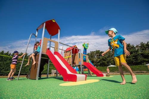 Grupa dzieci bawiących się na placu zabaw w obiekcie Camping Les Moutiers-en-Retz w mieście Prigny