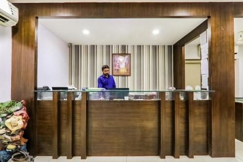 a man standing at a reception desk in a hotel lobby at Resort Sita Kiran in Bareilly