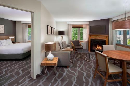 une chambre d'hôtel avec un lit et une cheminée dans l'établissement Residence Inn by Marriott Mont Tremblant Manoir Labelle, à Mont-Tremblant