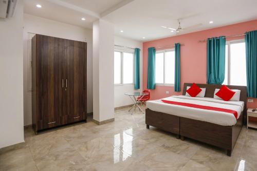 - une chambre avec un grand lit et des oreillers rouges dans l'établissement Jsb Hotel, à Faridabad
