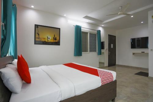 - une chambre avec un grand lit blanc et des oreillers rouges dans l'établissement Jsb Hotel, à Faridabad