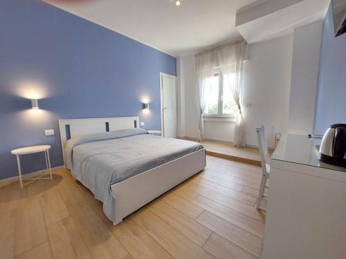 ein blaues Schlafzimmer mit einem Bett und einer Küche in der Unterkunft Ricomincio da Polignano in Polignano a Mare
