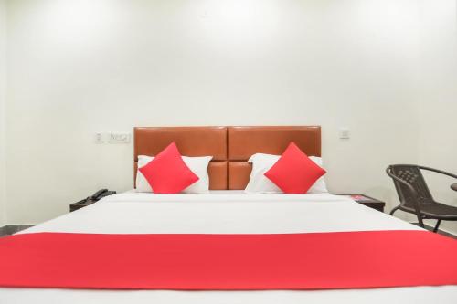 a bedroom with a red and white bed with chairs at Hotel Krishna in Faridabad