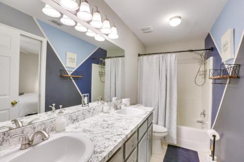 a bathroom with two sinks and a large mirror at Sleek Tallahassee Family Home - 5 Mi to Dtwn! in Tallahassee