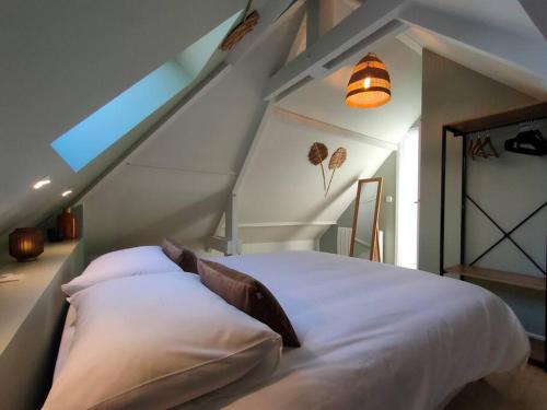 een slaapkamer met een bed in een kamer met een zolder bij La Closerie de Thimécourt in Luzarches