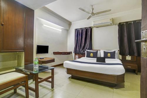 sypialnia z łóżkiem, stołem i telewizorem w obiekcie Townhouse OAK Utsav Residency w mieście Indore