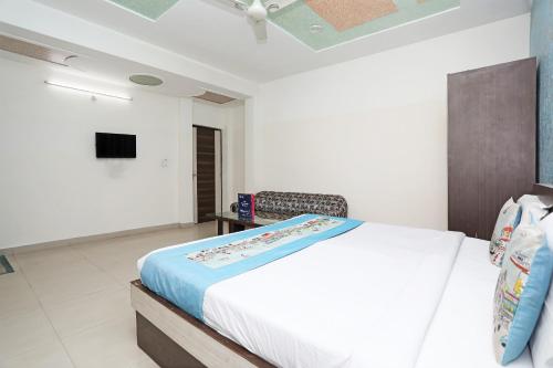 een slaapkamer met een groot bed en een televisie bij OYO Hotel Shanti Palace in Sikandra