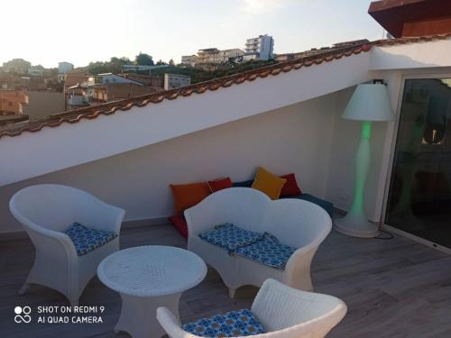 a balcony with chairs and a table and a couch at Casa Belvedere in Agrigento