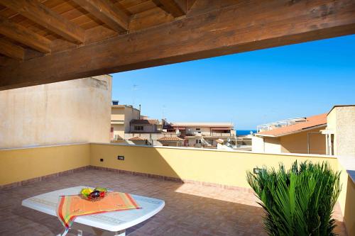 um pátio com uma mesa e vista para o oceano em Casa Vacanza Luigi em Castellammare del Golfo