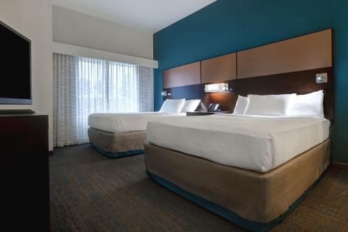 a hotel room with two beds and a flat screen tv at Residence Inn by Marriott Pullman in Pullman