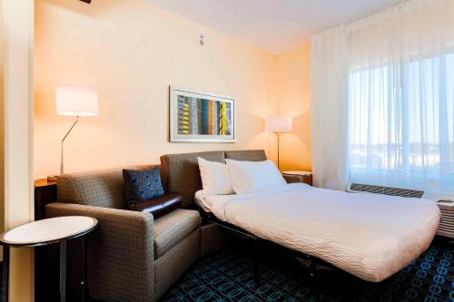 a hotel room with a bed and a chair at Fairfield Inn & Suites by Marriott Pecos in Pecos