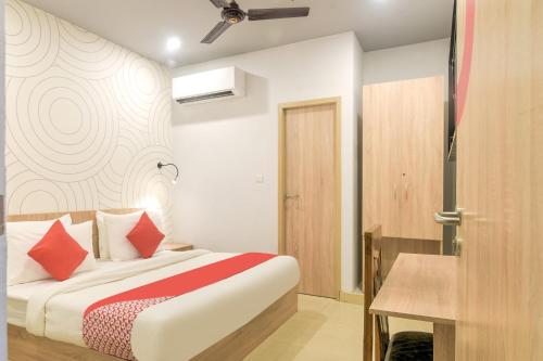 una camera da letto con un letto con cuscini rossi di Collection O Jps Grand Hotel Near Dwarka Metro Station a Nuova Delhi