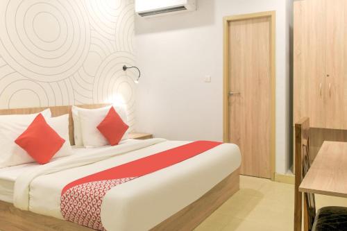 a bedroom with a bed with red and white pillows at Collection O Jps Grand Hotel Near Dwarka Metro Station in New Delhi