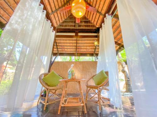 Cette chambre comprend une table, des chaises et un plafond. dans l'établissement Villano Lilawadee Pool Villa, à Na Jomtien