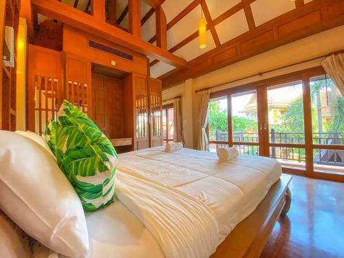 a large bed in a room with a large window at Villano Lilawadee Pool Villa in Na Jomtien