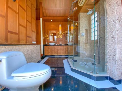 a bathroom with a toilet and a shower and a tub at Villano Lilawadee Pool Villa in Na Jomtien