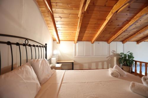 a bedroom with a large bed with a wooden ceiling at Seaside Gialova in Pylos