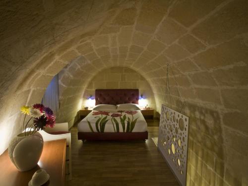 マテーラにあるLa Perla dei Sassiの石壁のベッドルーム1室