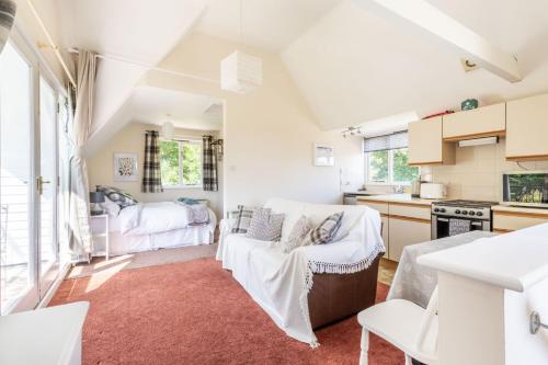 a living room with a couch and a kitchen at The Lodge at Alderfen View in Neatishead