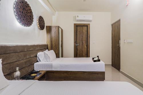 a hotel room with two beds and a door at Super Townhouse 83601 Hotel Marina in Rānchī