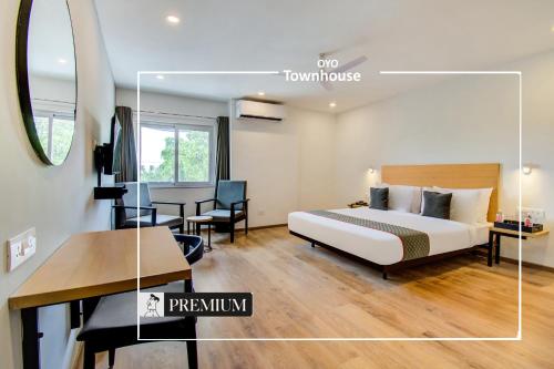 a hotel room with a bed and a table and a desk at Townhouse 165 Netaji Road in Ahmedabad