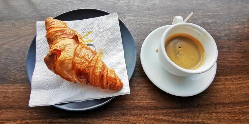 a plate with a croissant and a cup of coffee at Don Carlos in Paguera