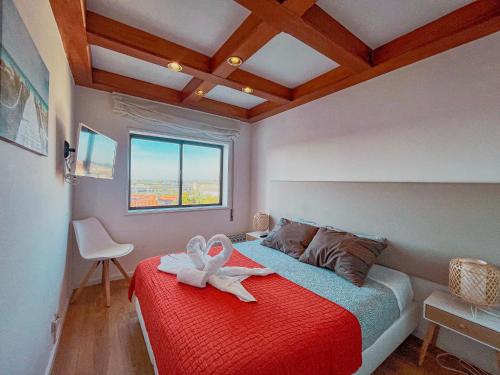a bedroom with a red bed with a white ribbon on it at Aveiro House - City Center Rooms in Aveiro