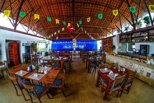 a restaurant with wooden tables and chairs and a bar at Hotel Fazenda Triunfo in Areia