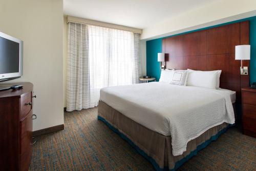 um quarto de hotel com uma cama grande e uma televisão de ecrã plano em Residence Inn San Diego Oceanside em Oceanside