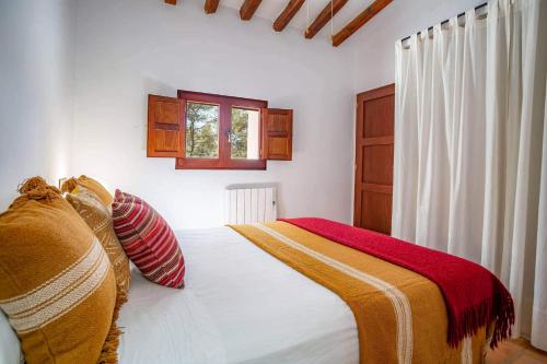 a bedroom with a bed and a window at Can Font in Santa Eularia des Riu